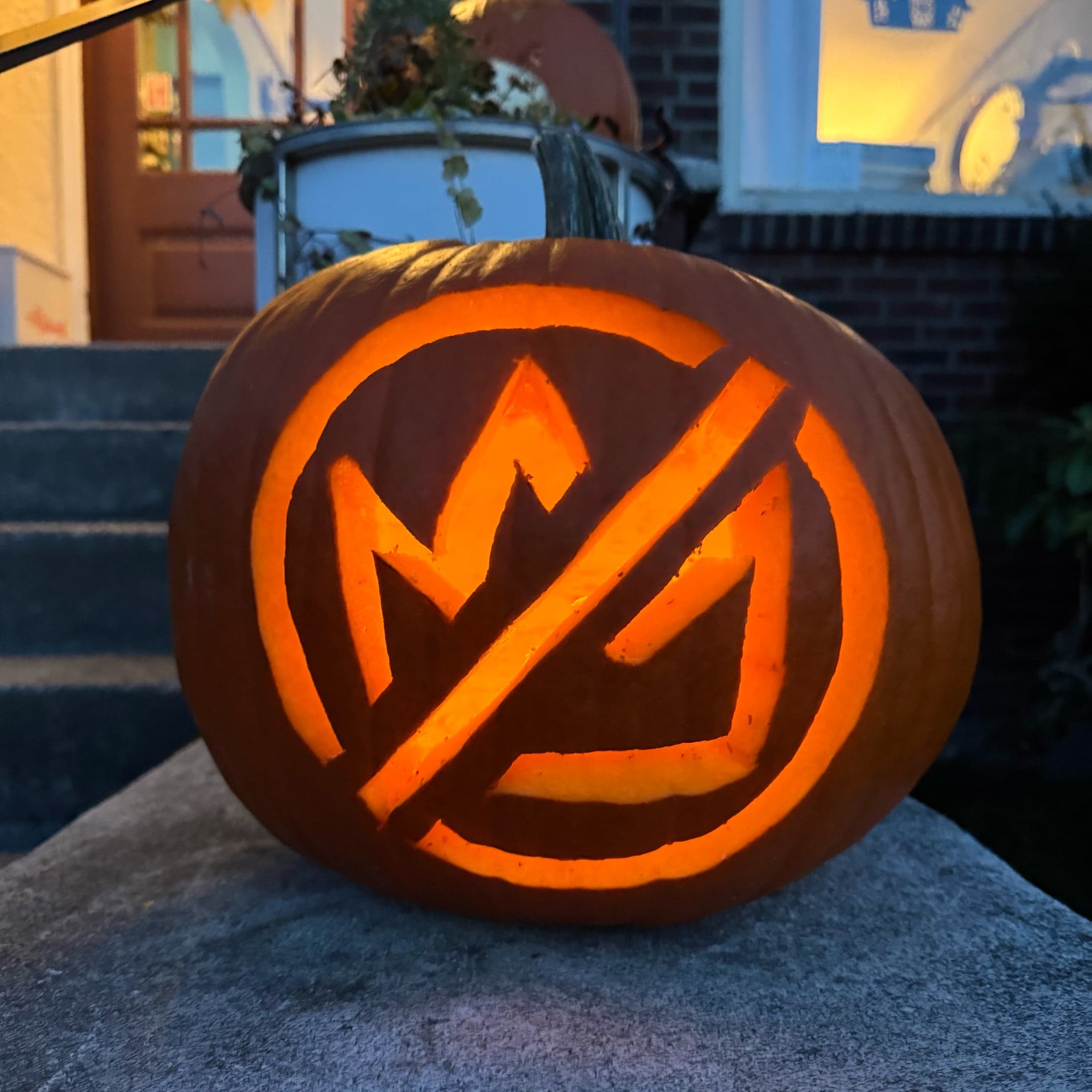 No Kings jack-o-lantern illuminated at night